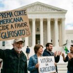 cartaz principal, que diz "SUPREMA CORTE AMERICANA DECIDE A FAVOR DO GLIFOSATO", e o cartaz menor que a mulher segura, "VITÓRIA DA AGRICULTURA", deixam claro o motivo da comemoração. Embora na vida real a situação jurídica nos EUA tenha sido complexa (com a Suprema Corte tendo rejeitado alguns recursos importantes da Bayer e aceitado julgar outros relacionados à rotulagem), a imagem ilustra uma vitória decisiva para o setor que defende o uso do herbicida.